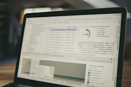 Laptop screen displaying code and data charts.