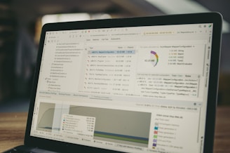Laptop screen displaying code and data charts.
