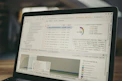 Laptop screen displaying code and data charts.