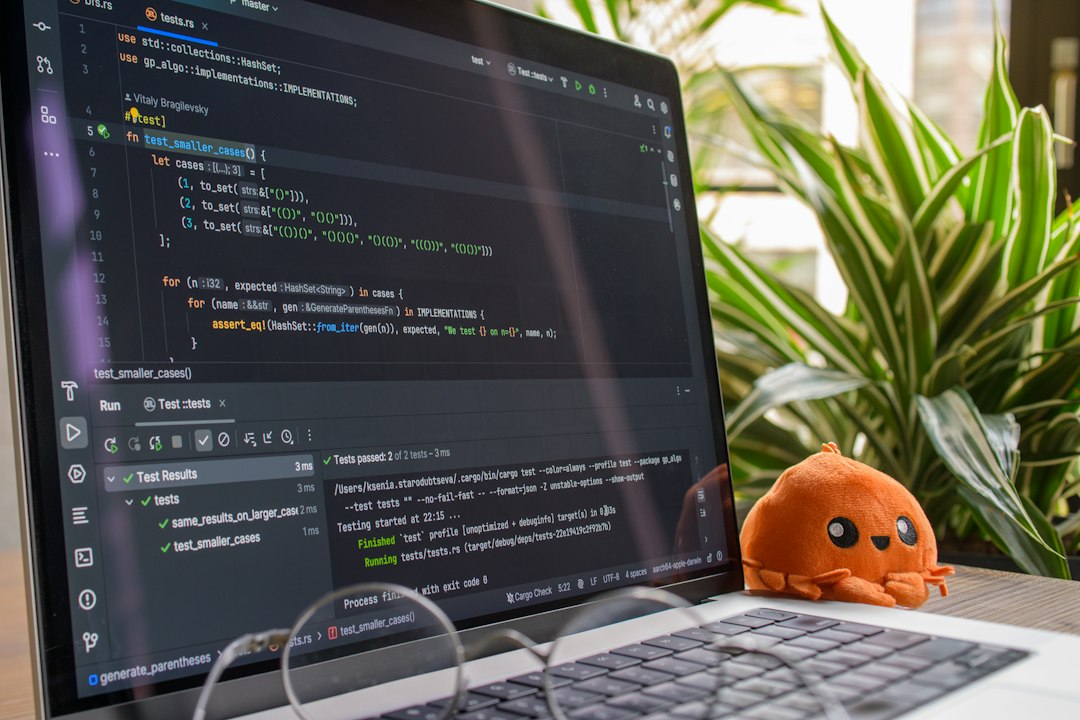 Laptop screen displaying code with a small octopus toy.