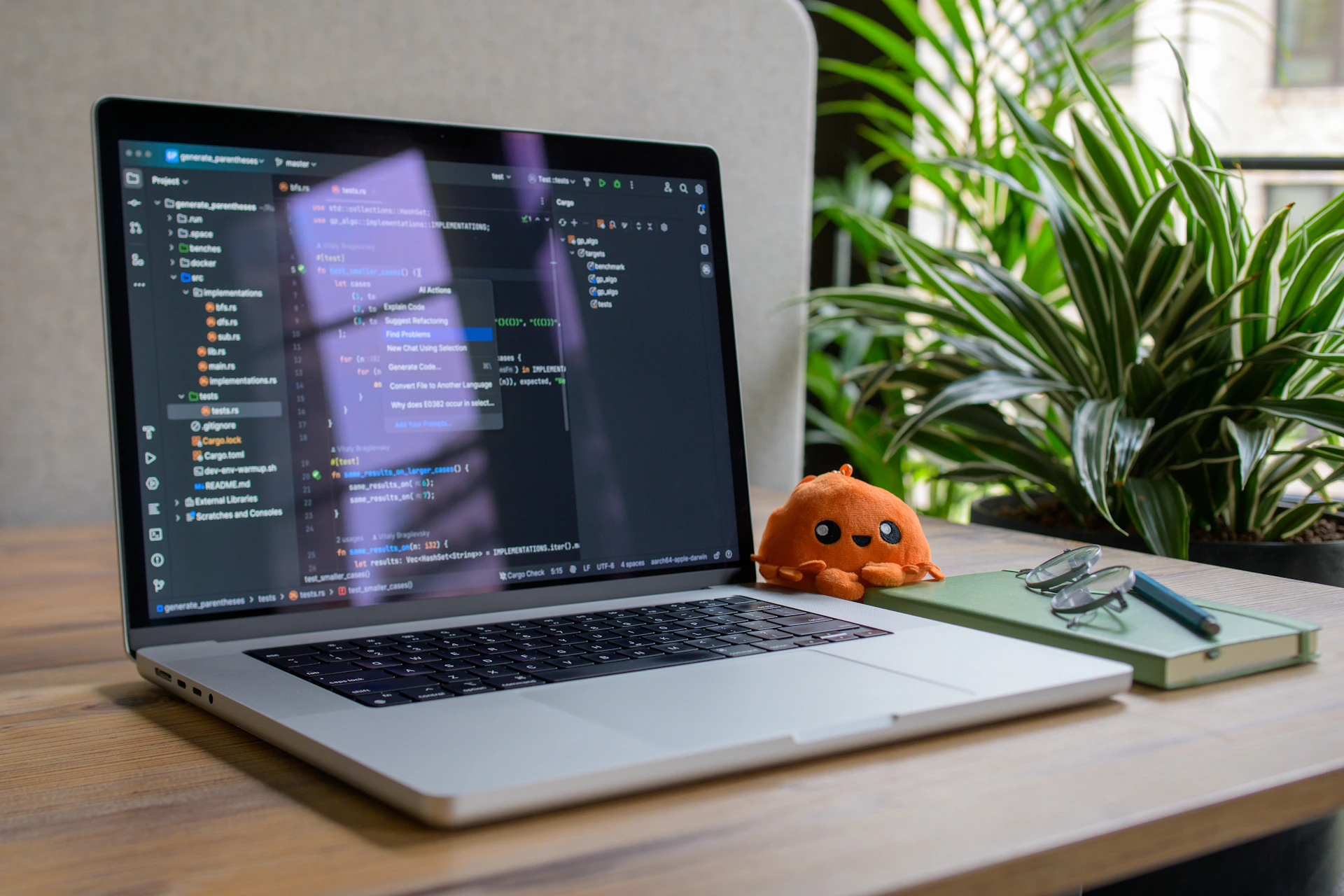 Laptop displaying code with small stuffed toy nearby