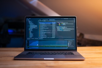Laptop screen displaying code and data graphs.