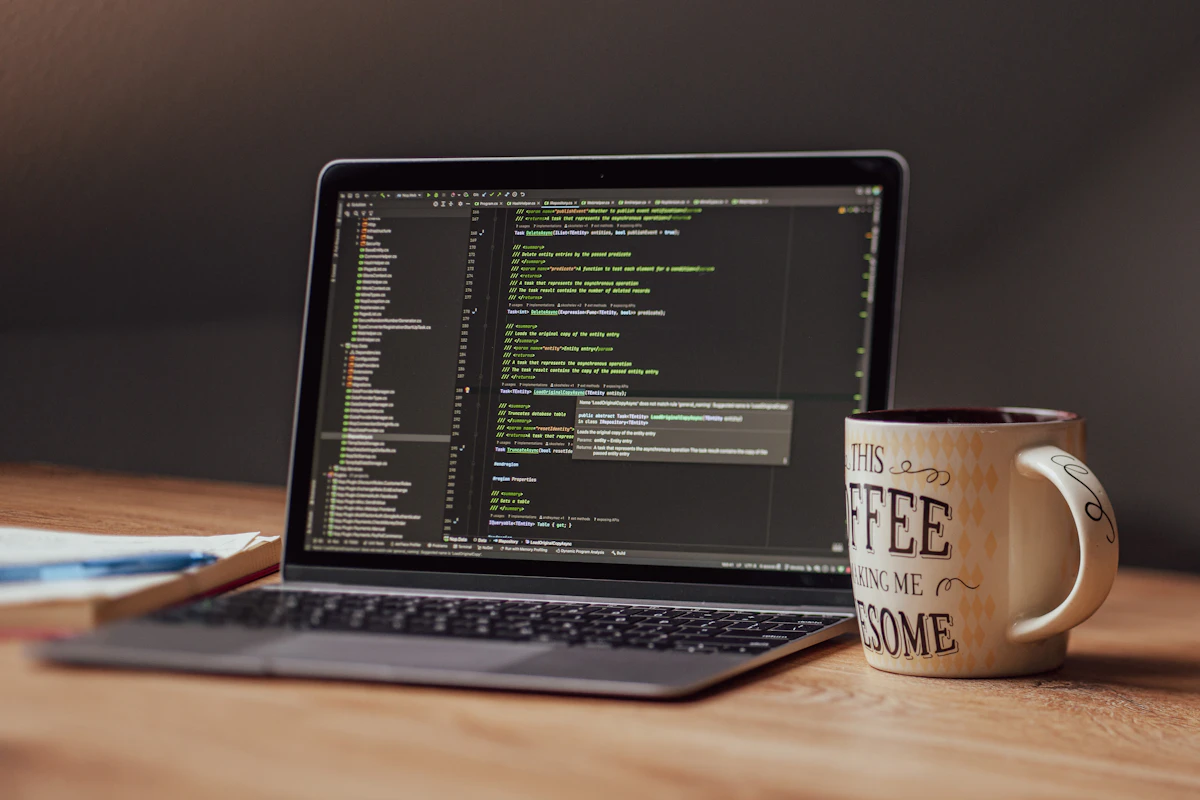 Laptop displaying code with a coffee mug nearby
