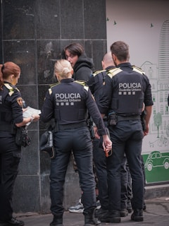 Police officers surround a person on a street.
