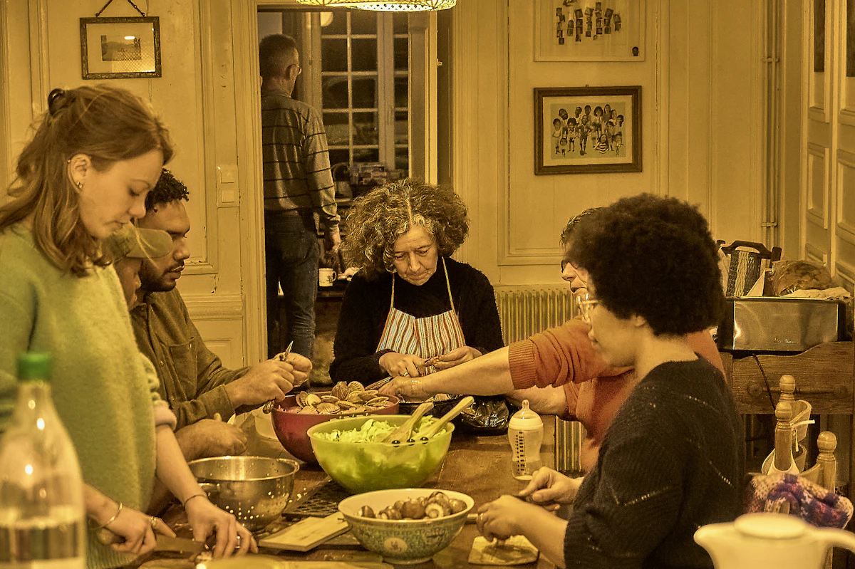 A group of people preparing a meal together around a table