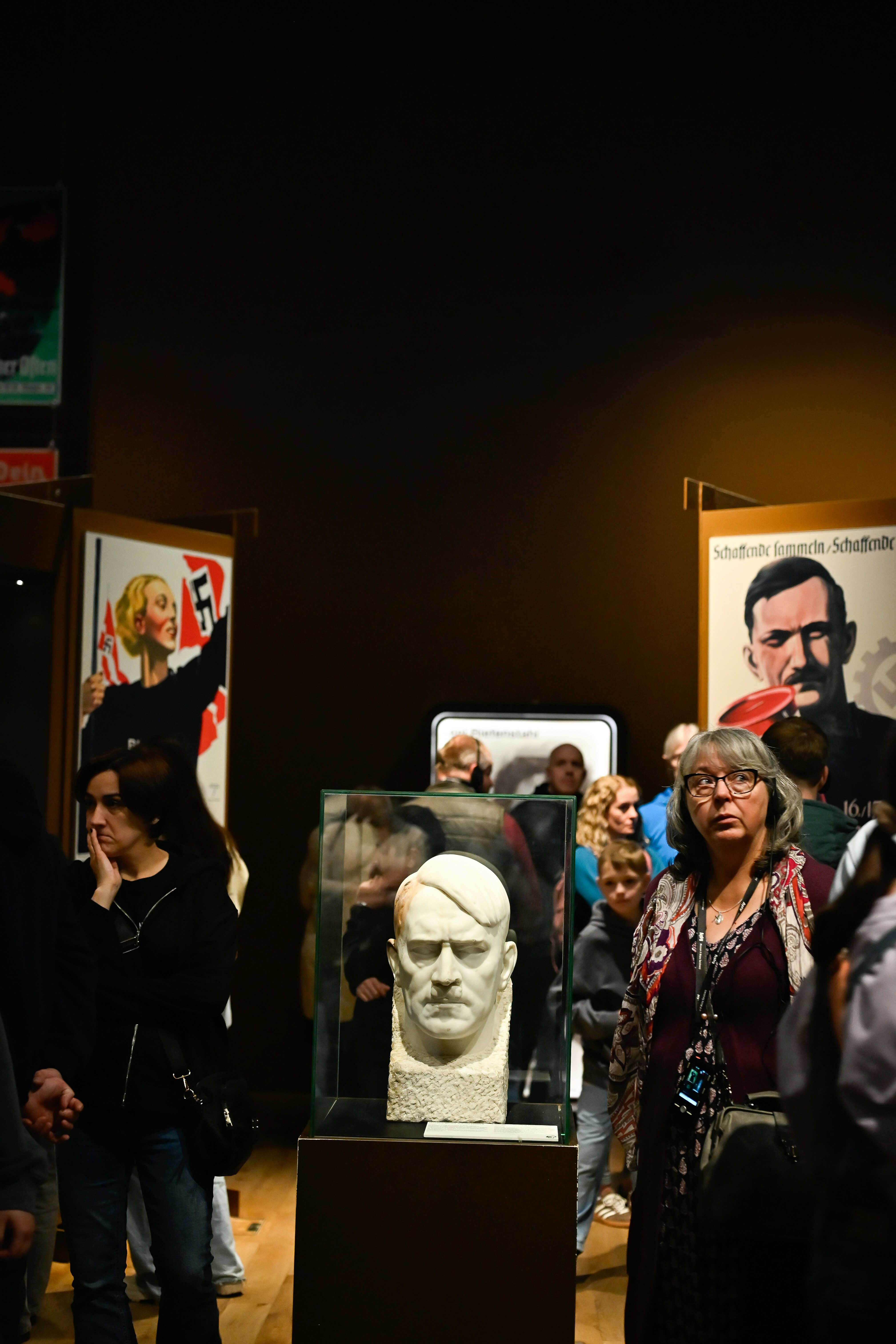 People observe a bust in a museum exhibit.
