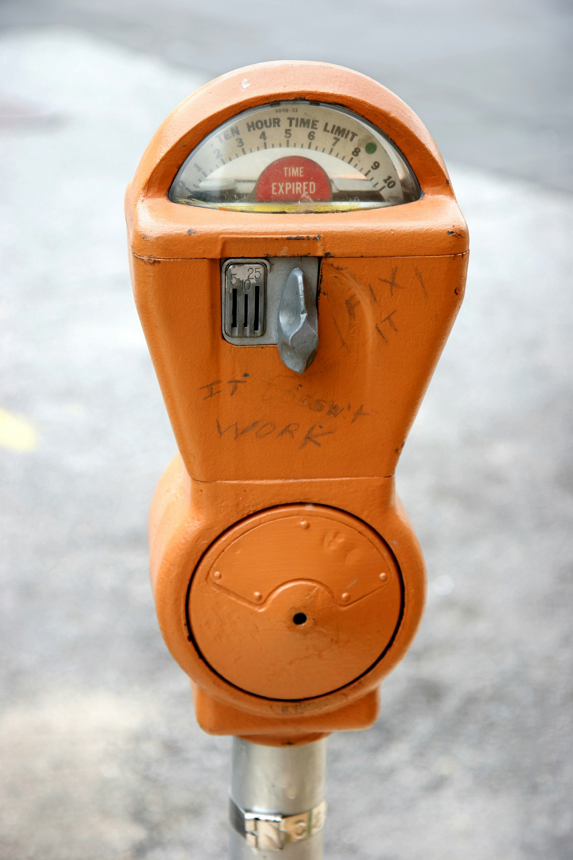 Oranger Parkuhr mit abgelaufener Zeitanzeige.