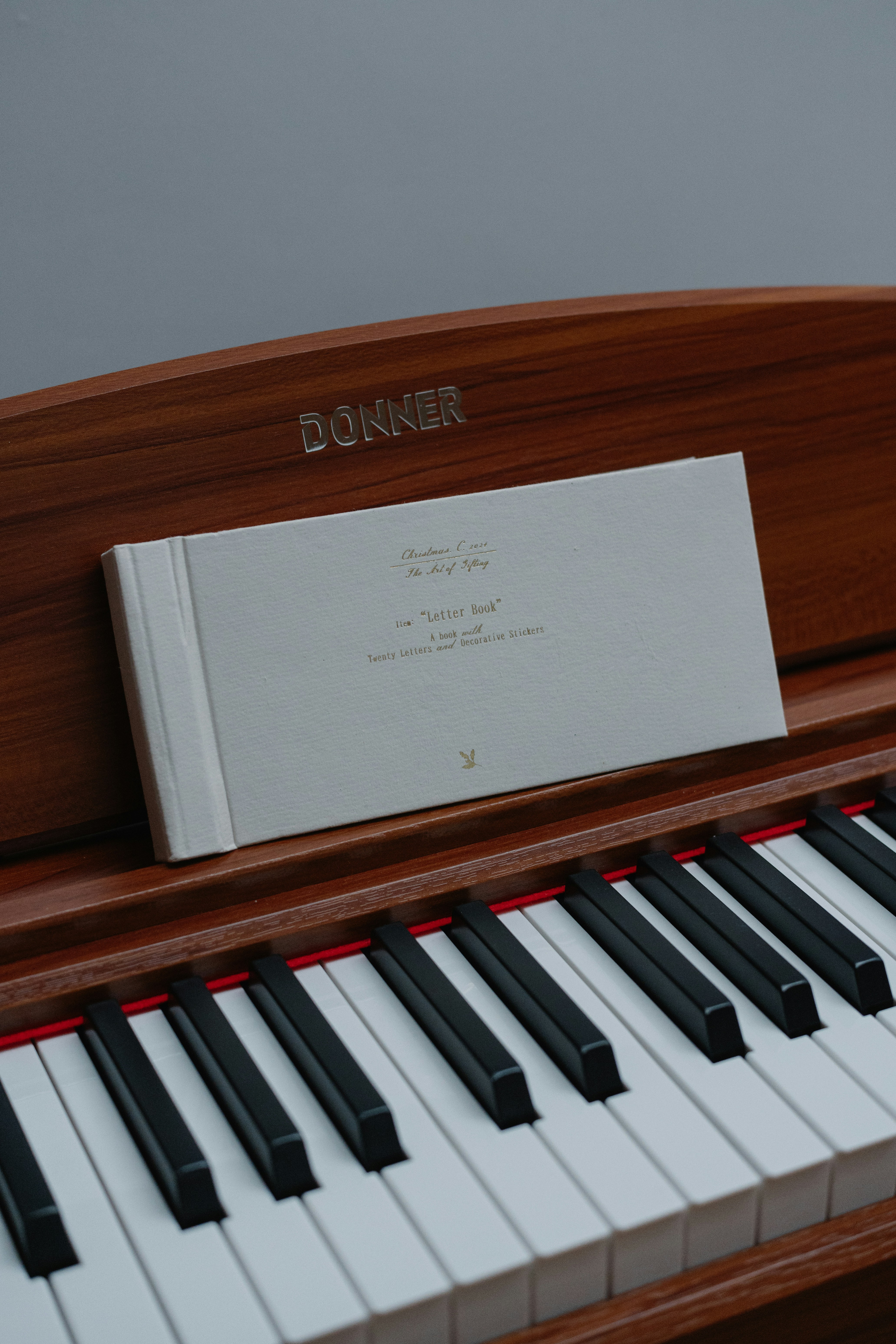 A sheet music book rests on a piano.
