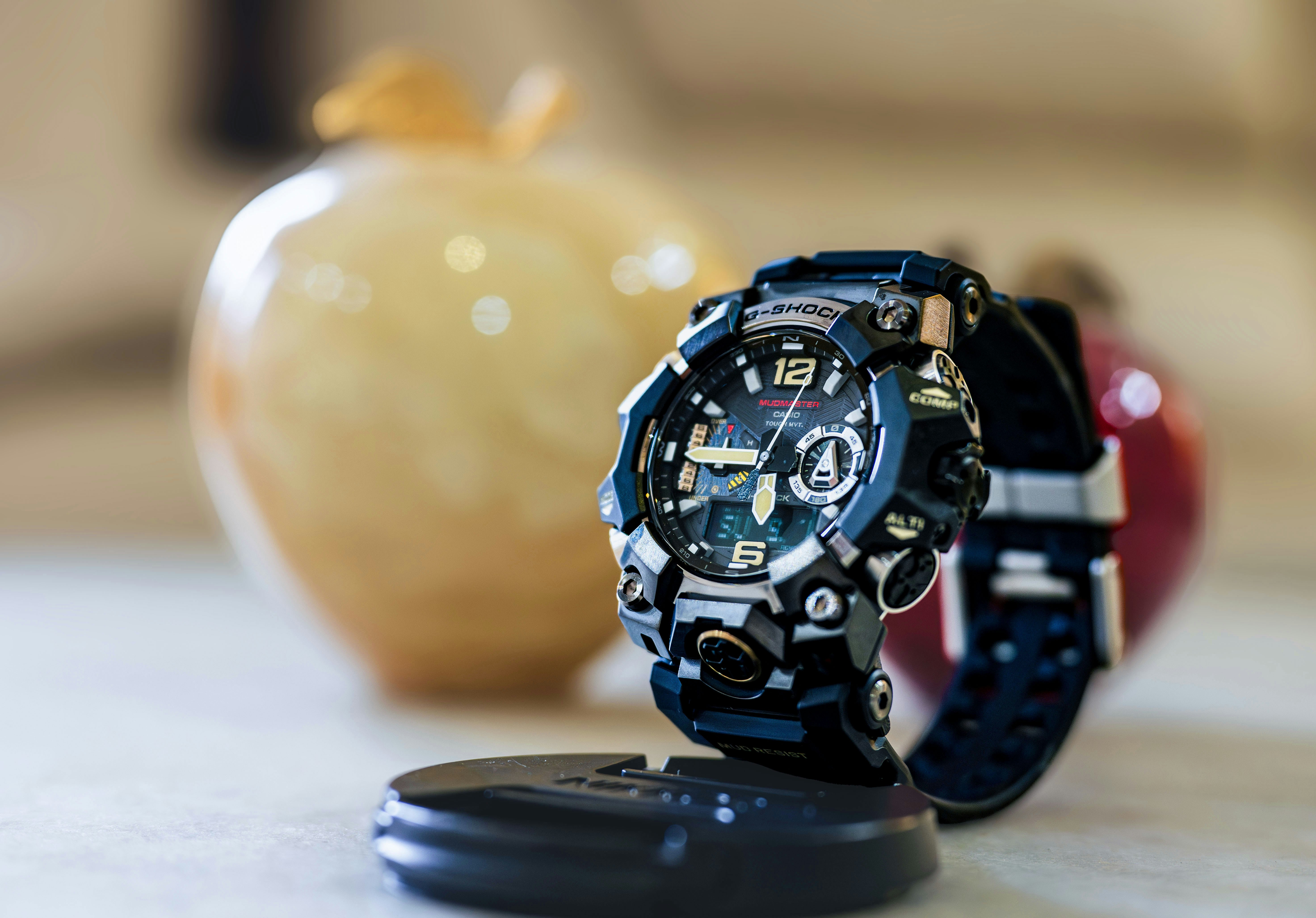 A rugged digital watch displayed on a stand.