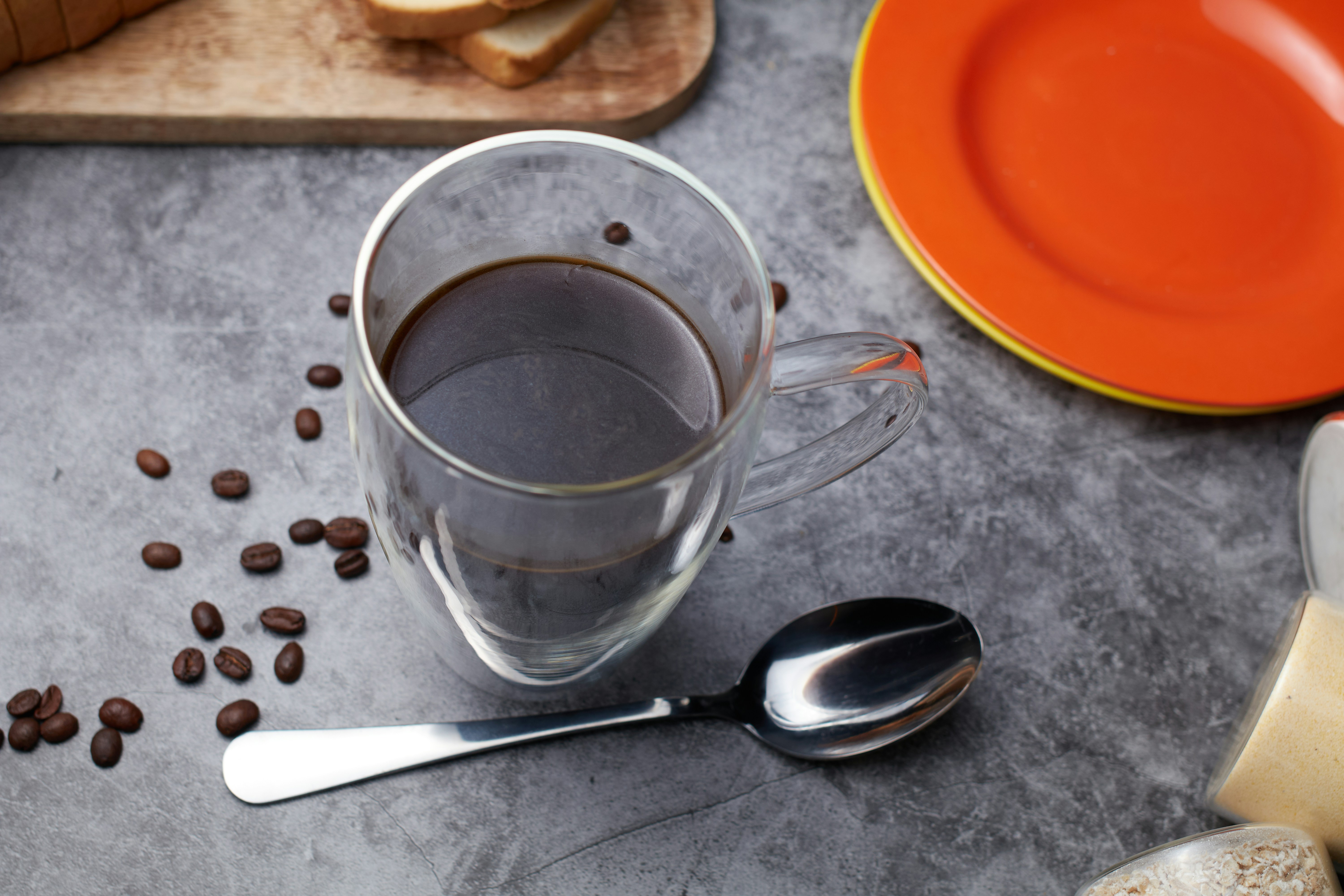 A cup of coffee with a spoon and toast.
