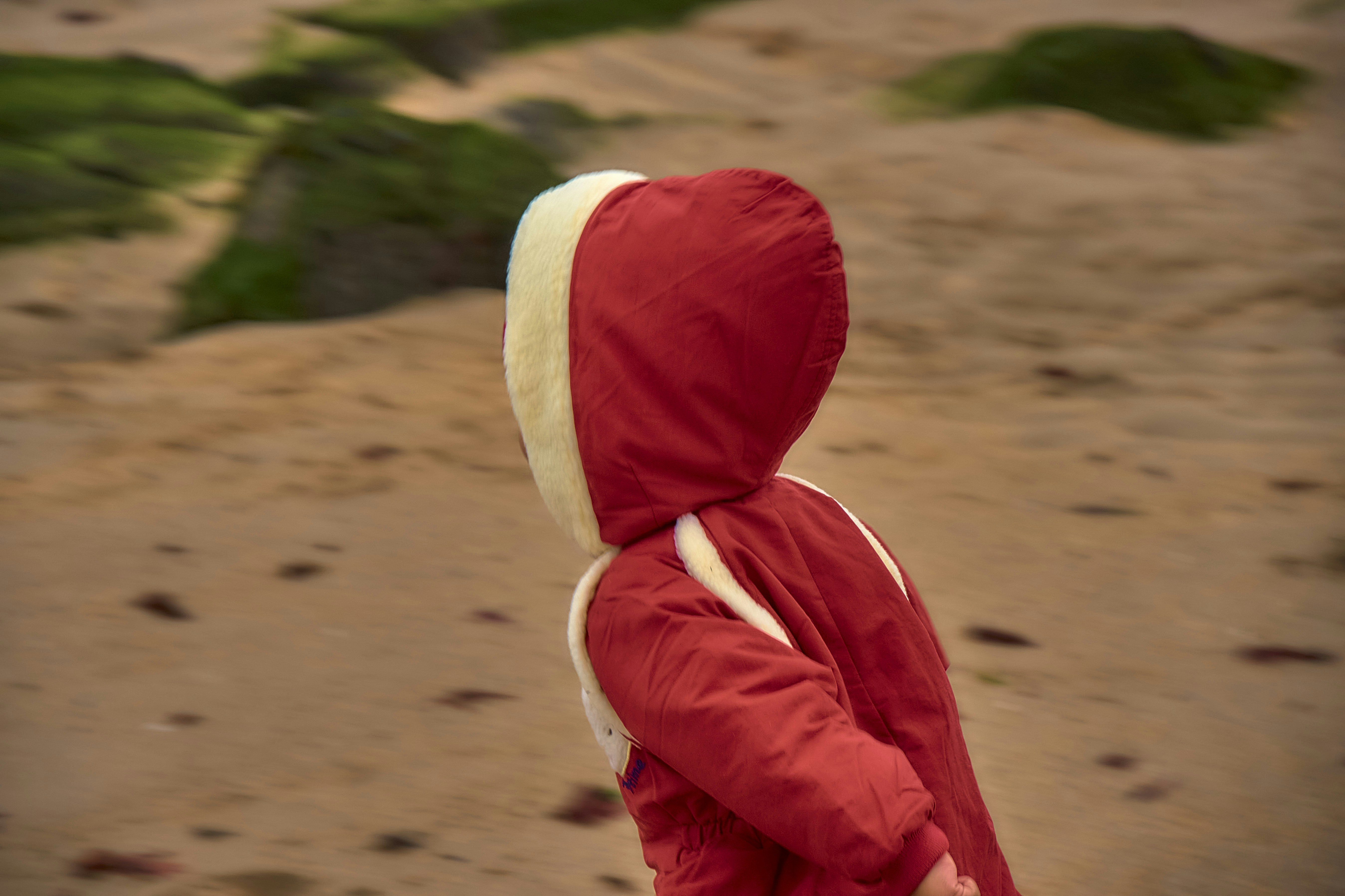 Child in red coat on a sandy beach