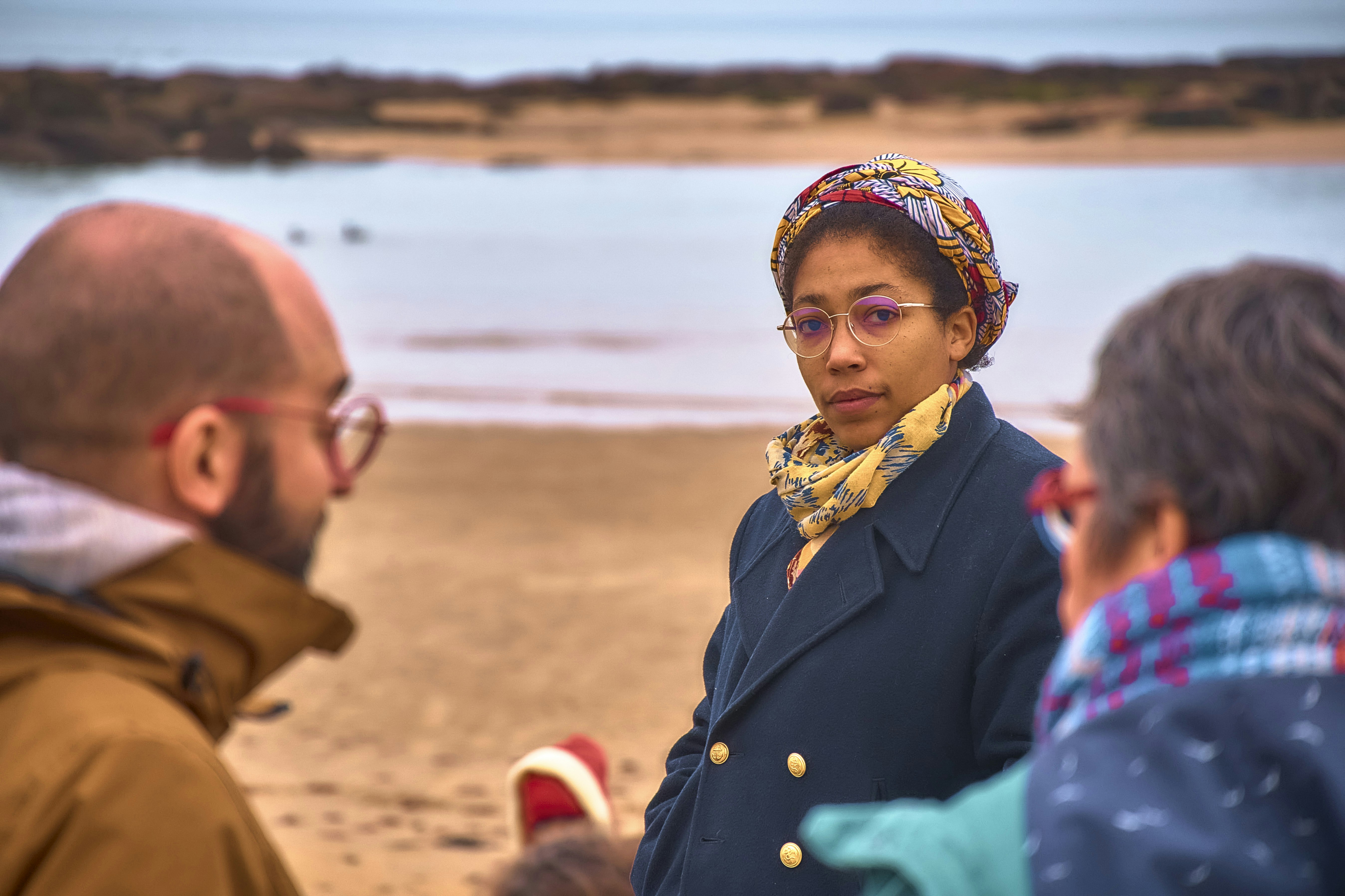 Three people on a beach near the ocean
