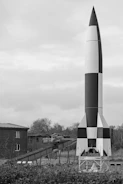 Large rocket with checkered pattern stands outdoors