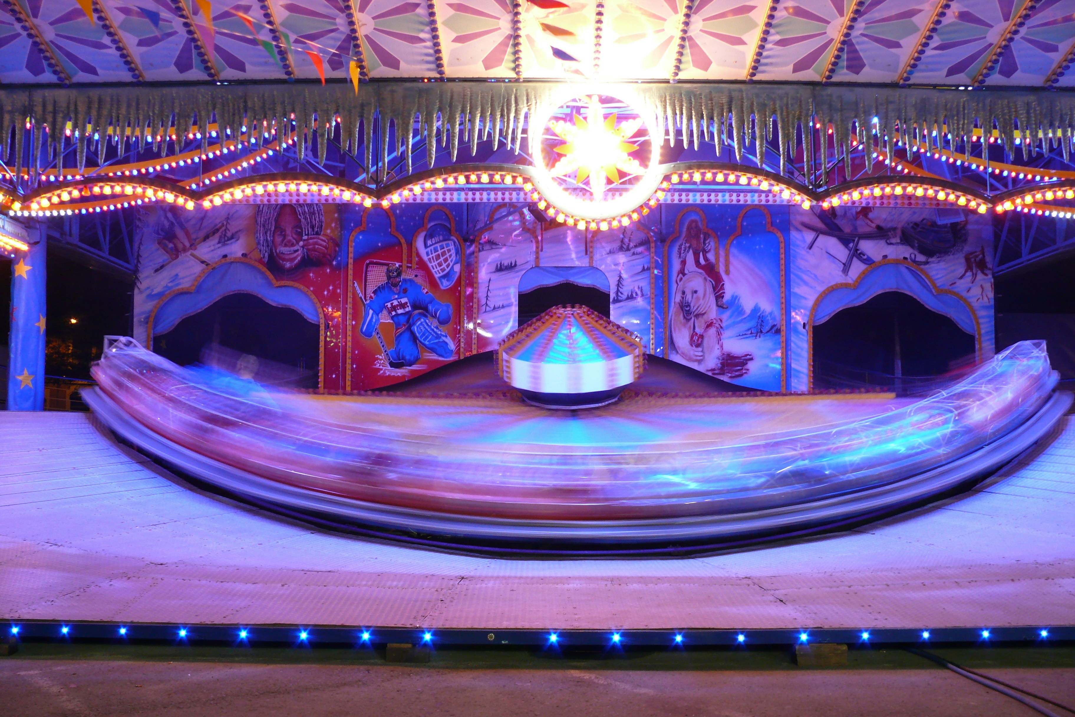 Carnival ride spinning with colorful lights at night