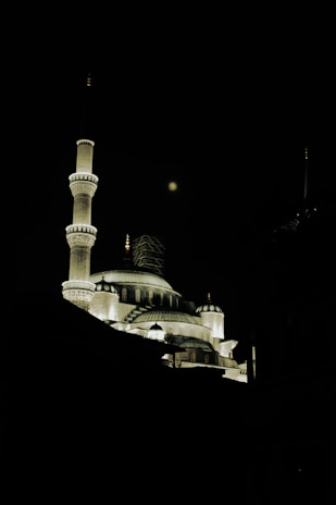 Illuminated mosque with minarets at night