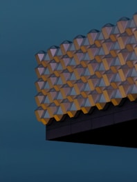 Geometric facade illuminated against dark sky