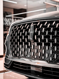 Close-up of a modern car grille with emblem.