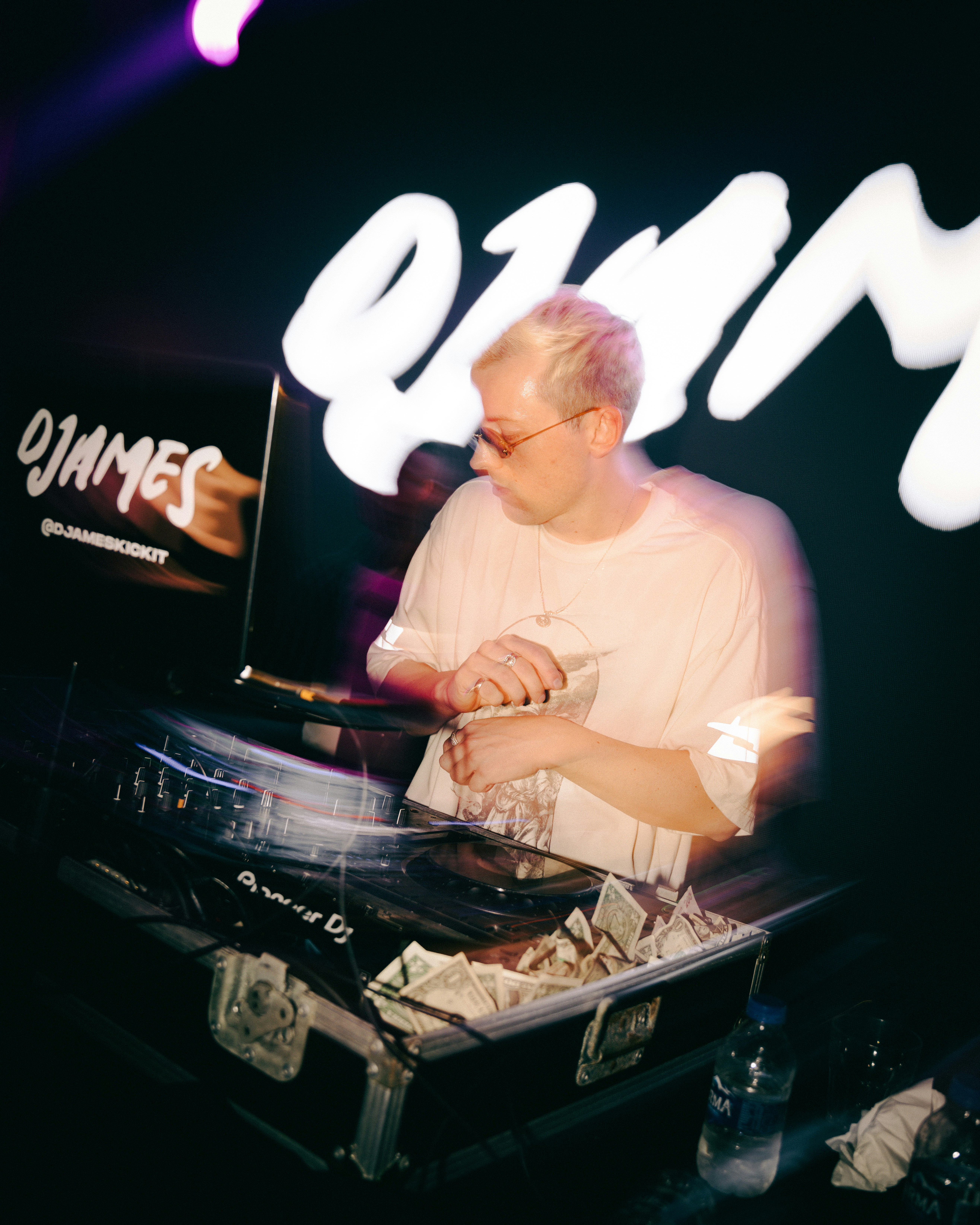 Dj playing music on turntables at a club