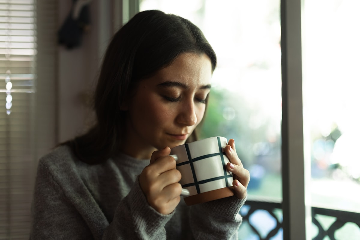 Vrouw in zacht ochtendlicht met kopje thee, lente-sfeer