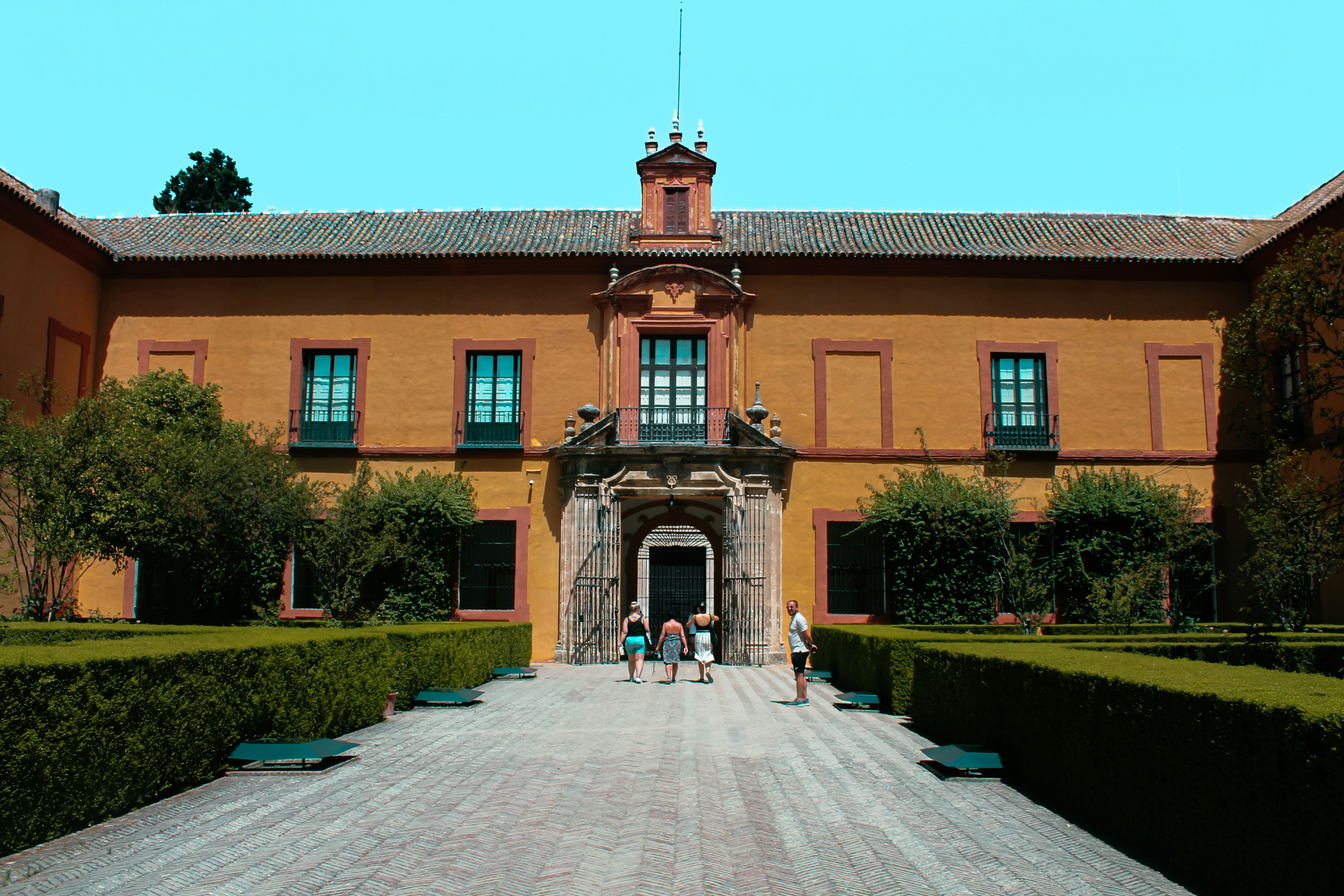 People walking towards a large historic building entrance.