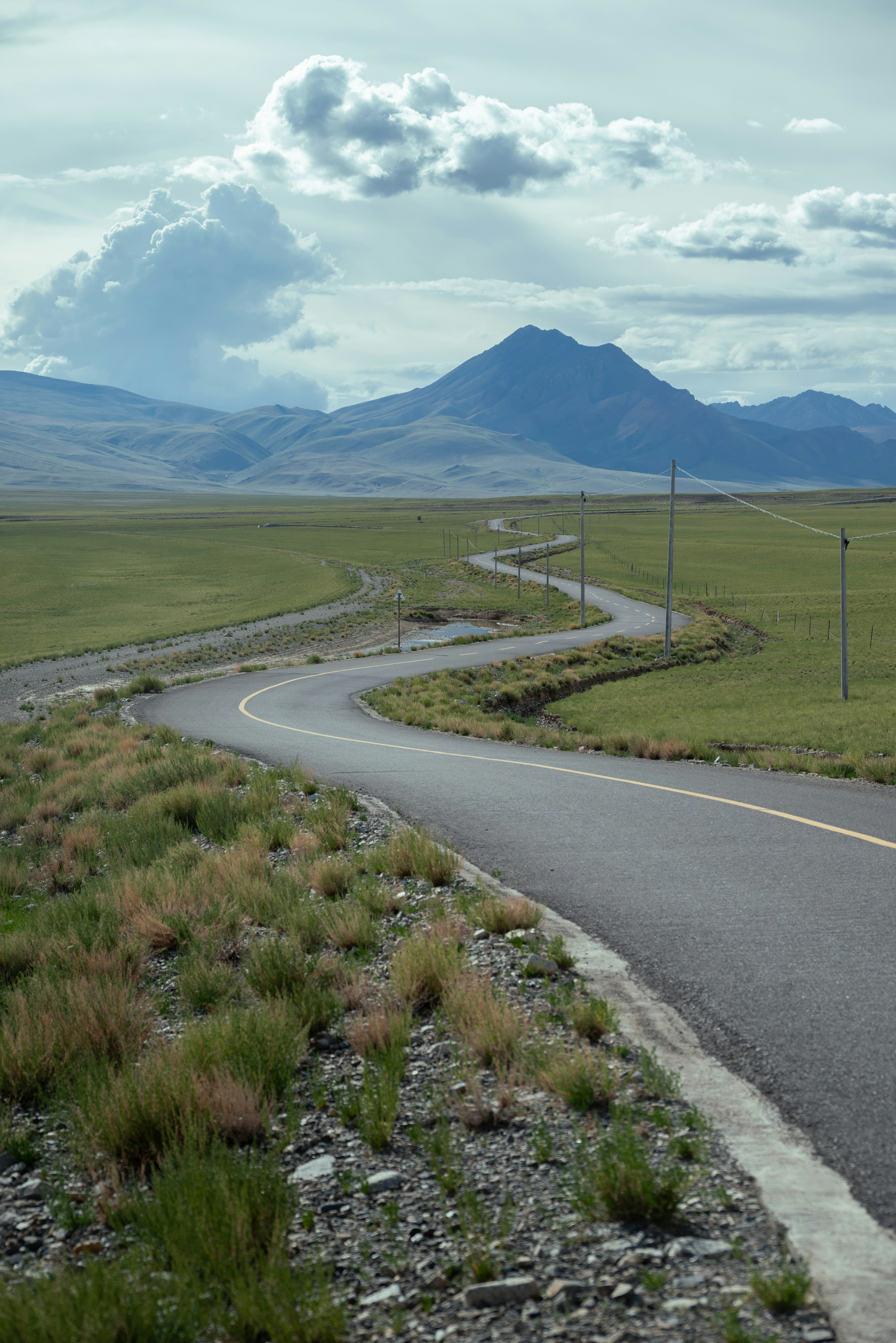 Winding road through a vast green landscape