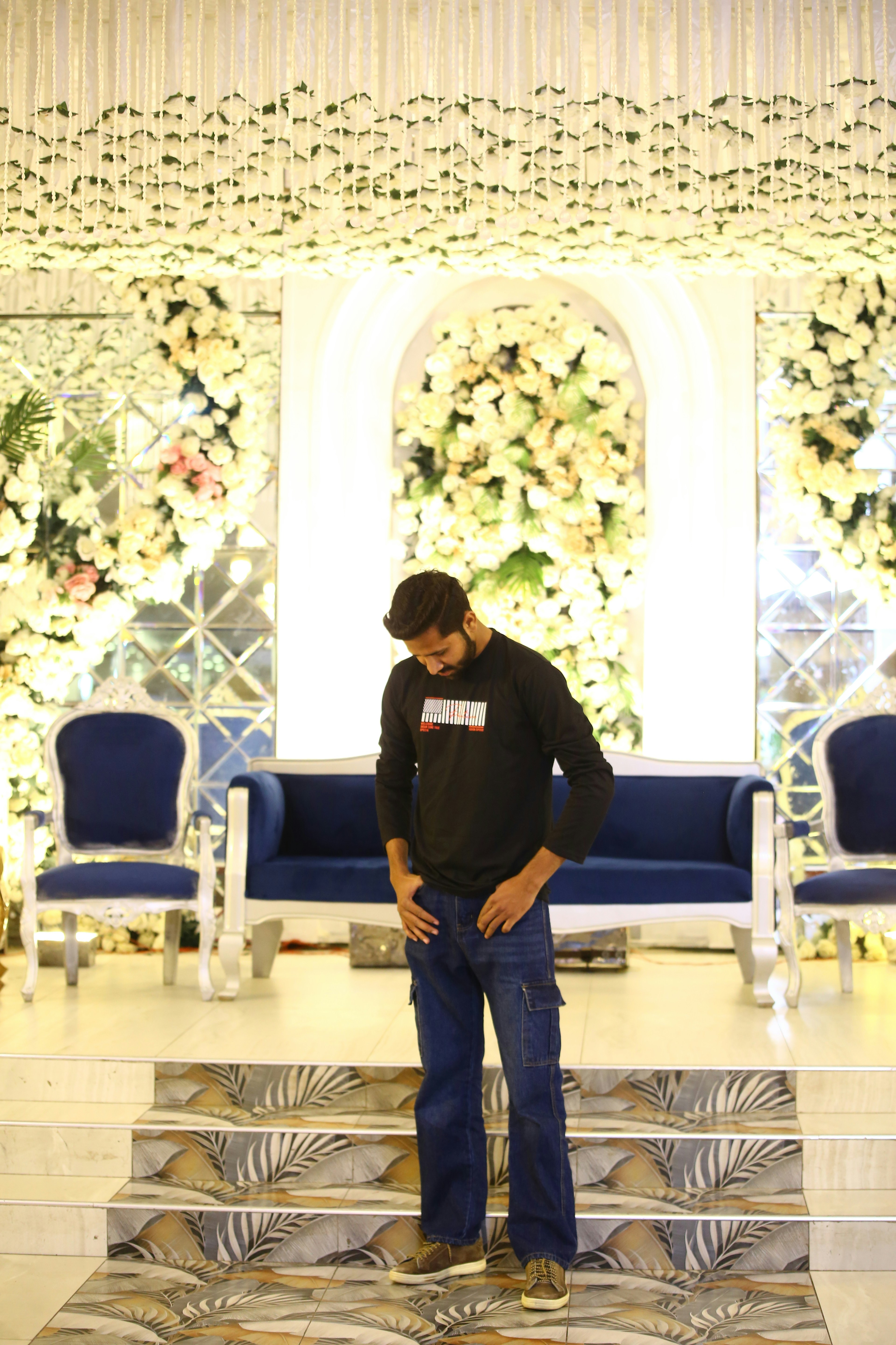 Man standing on decorated stage with floral backdrop