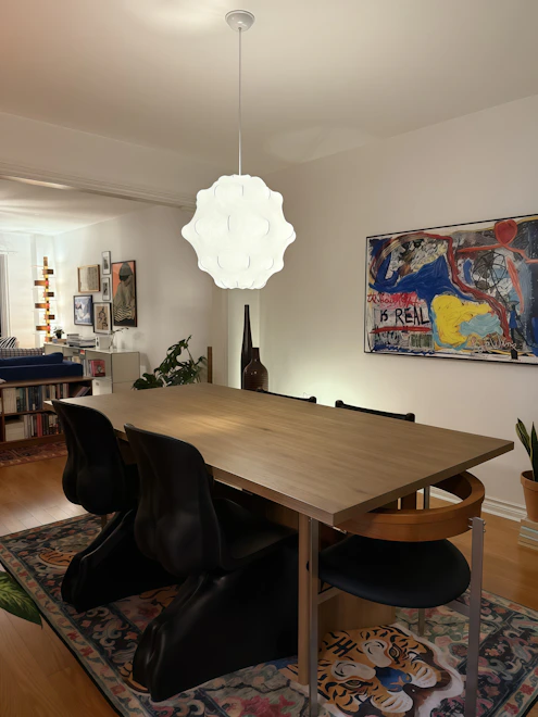 Dining room with wooden table and modern chairs.