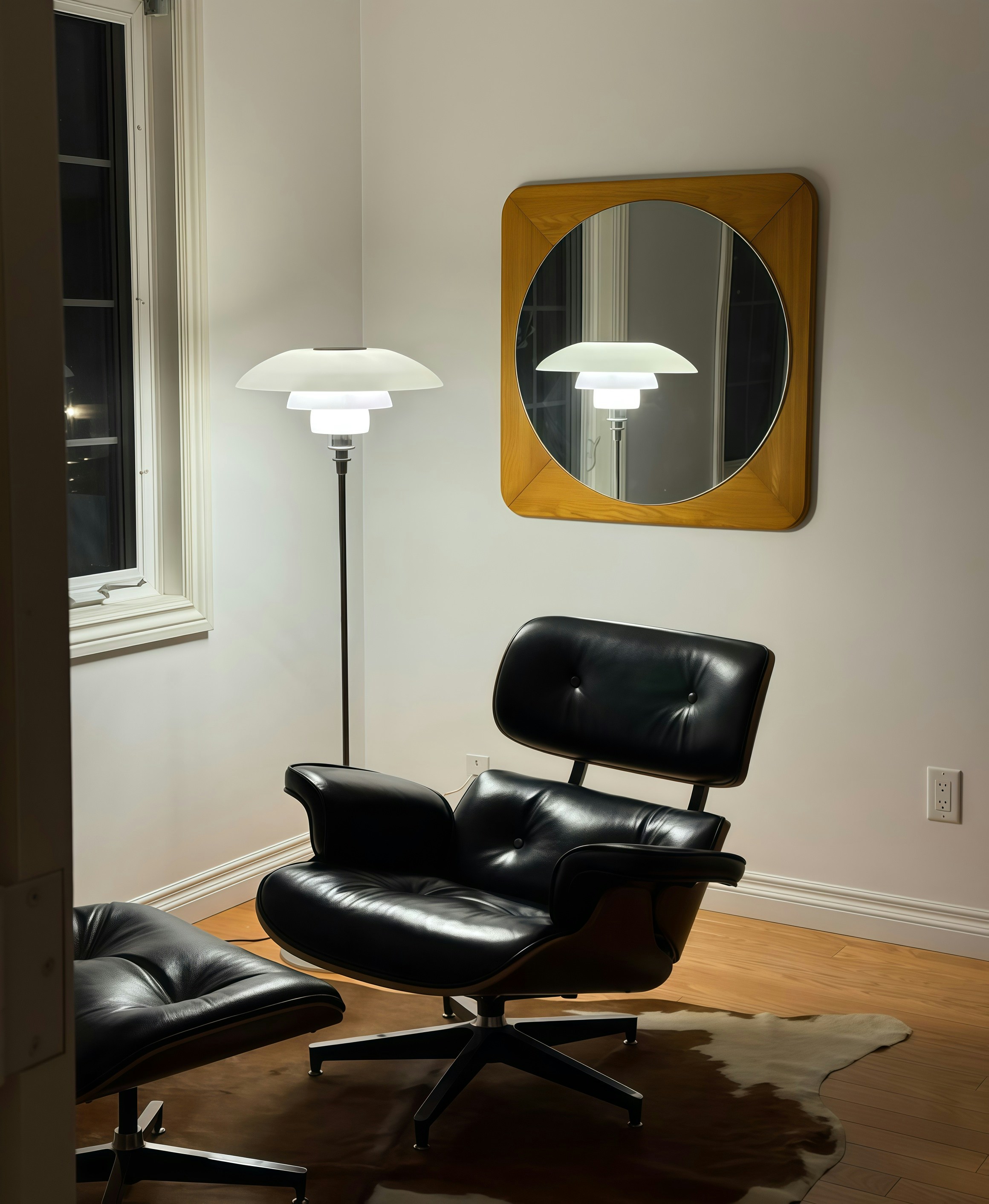 Black leather lounge chair and ottoman with floor lamp.