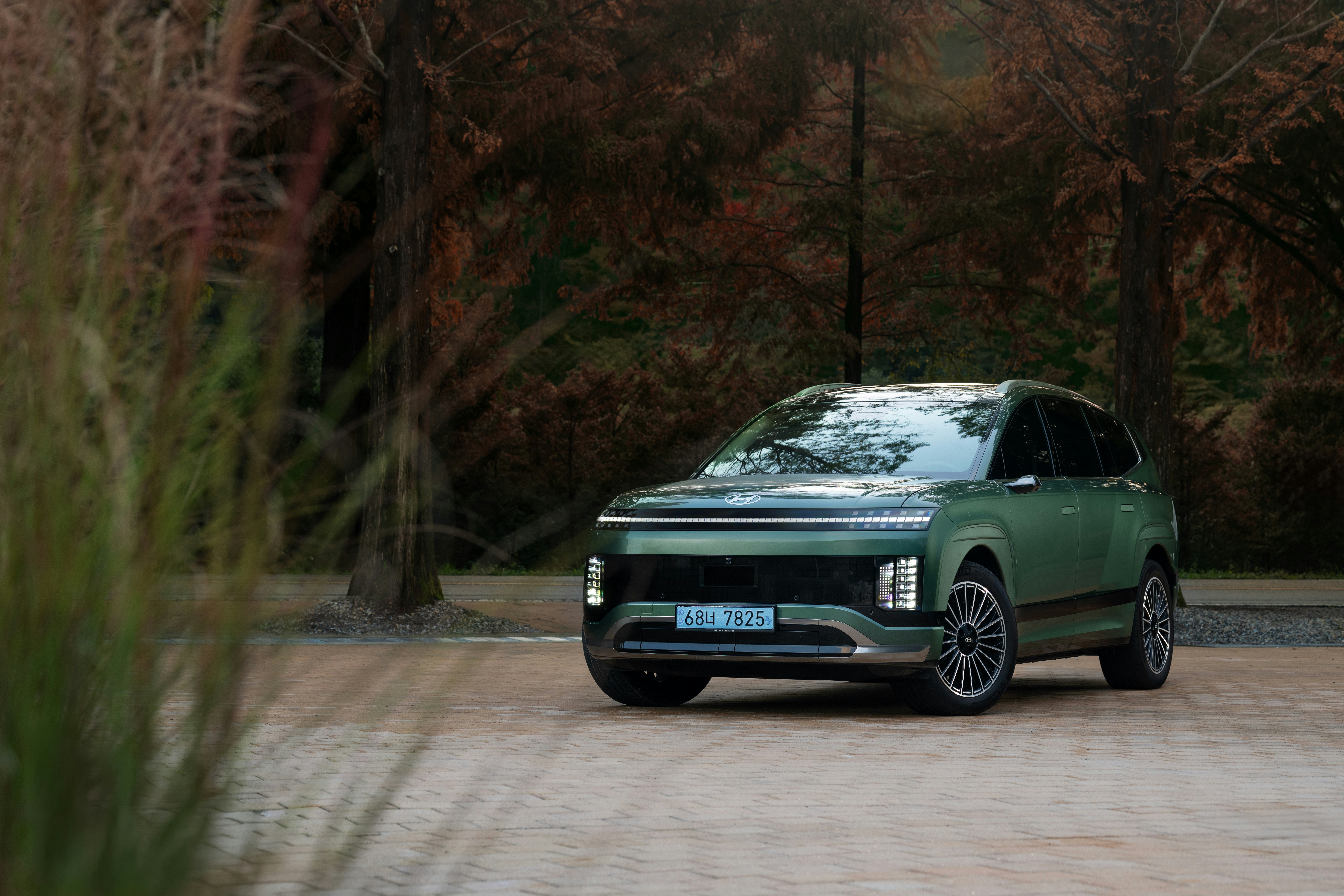 A green suv parked on a paved surface.
