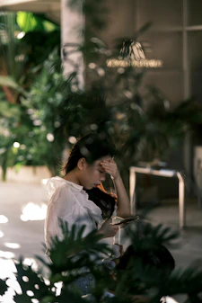 Woman holding her head while looking at phone
