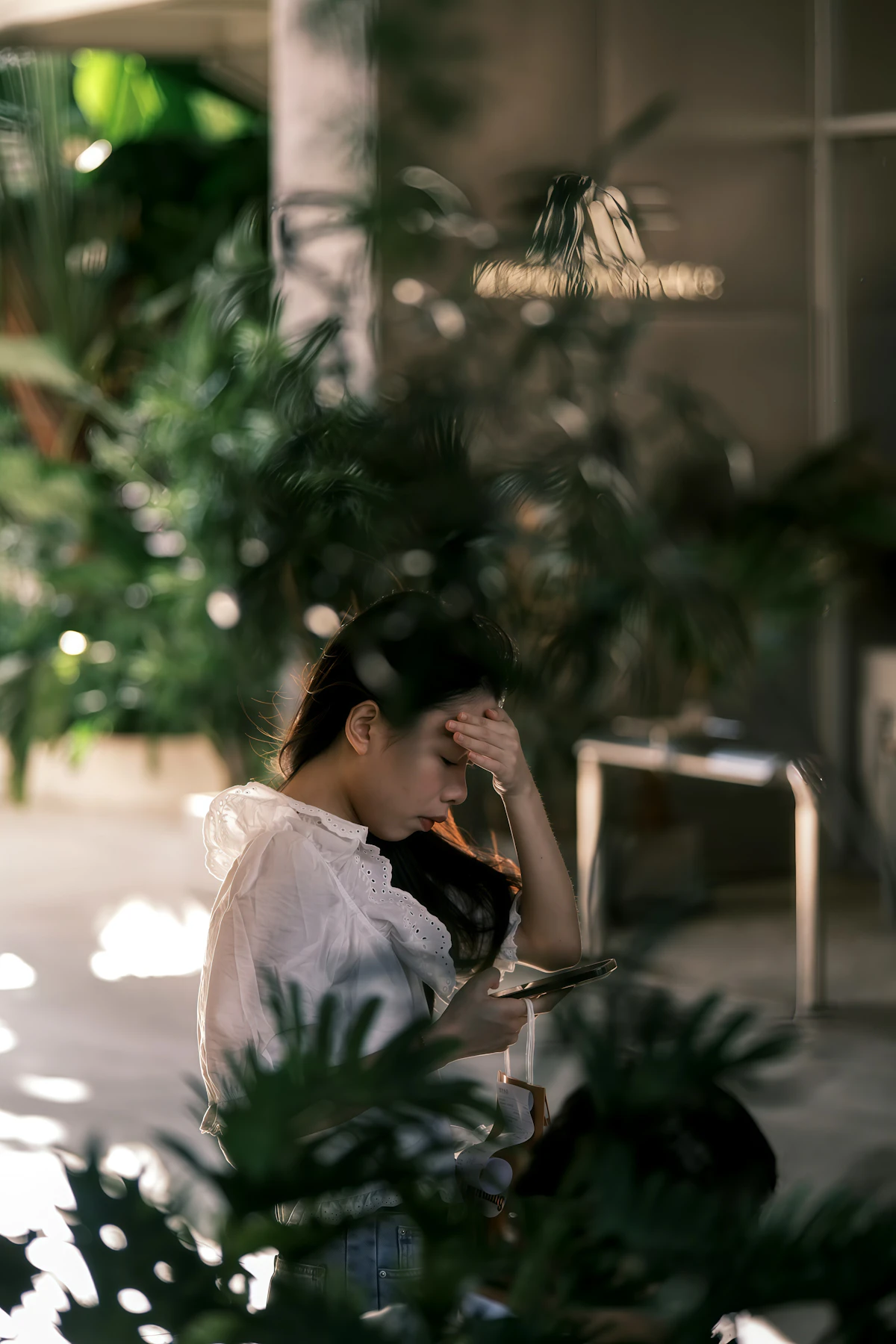 Woman holding her head while feeling stressed, illustrating anxiety and discomfort that may occur after unexpectedly strong cannabis intoxication