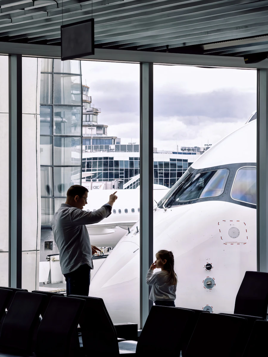 A parent and child watching an aircraft from the departure gate