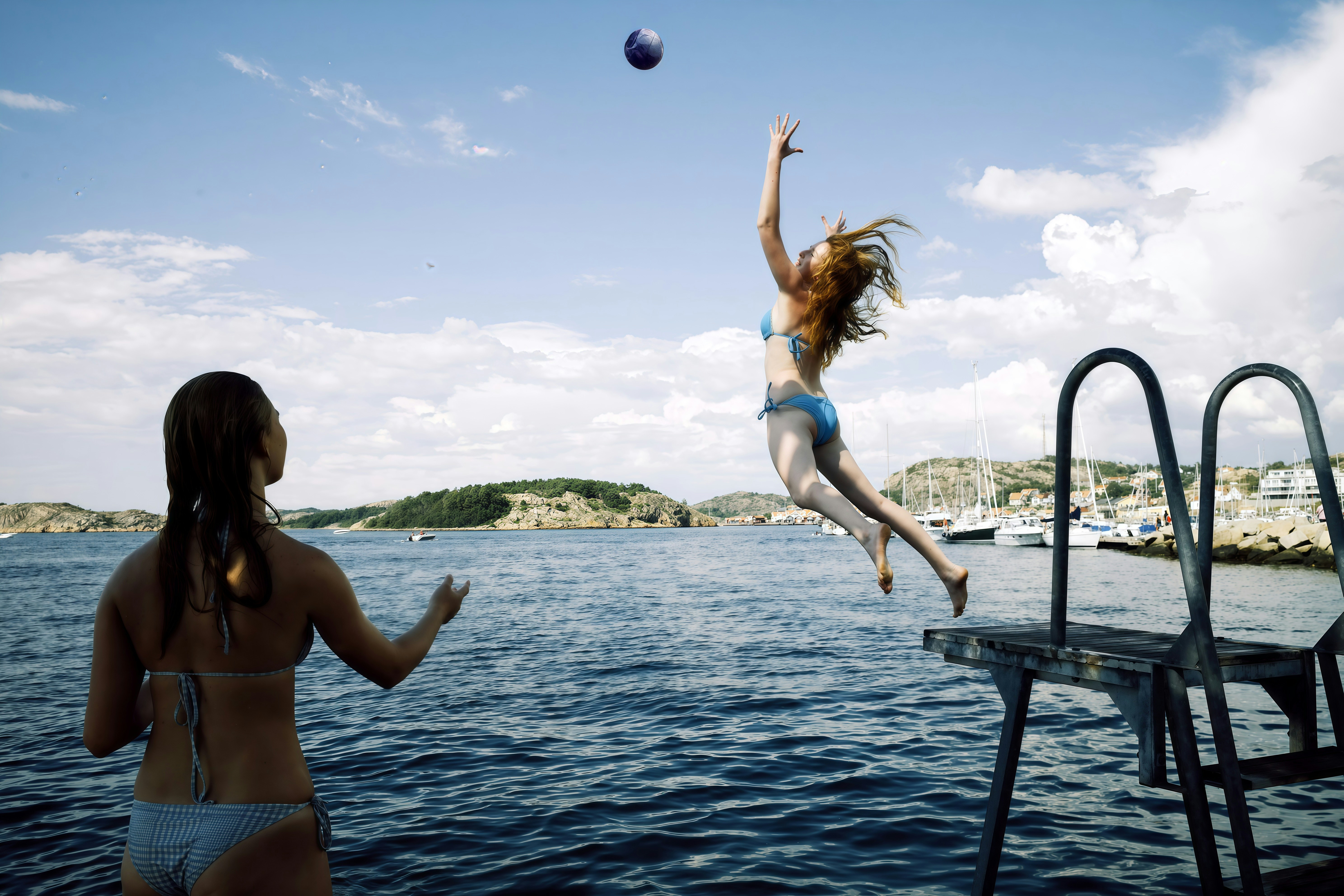 Two women playing volleyball by the water - 相关推荐