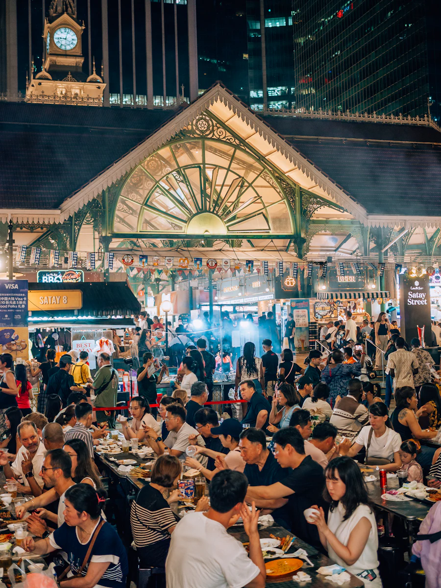 Volles Hawker Centre mit Essensständen und Gästen an langen Tischen