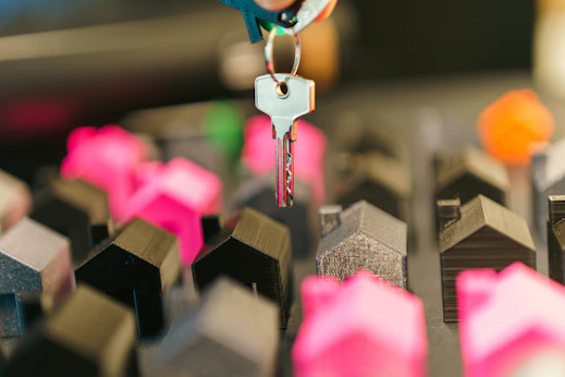Hand holding a key above miniature houses