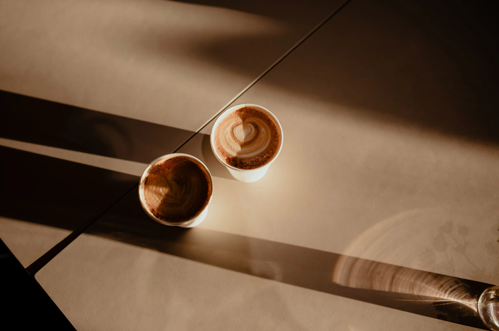 Zwei Kaffeetassen auf einem Tisch im Abendlicht