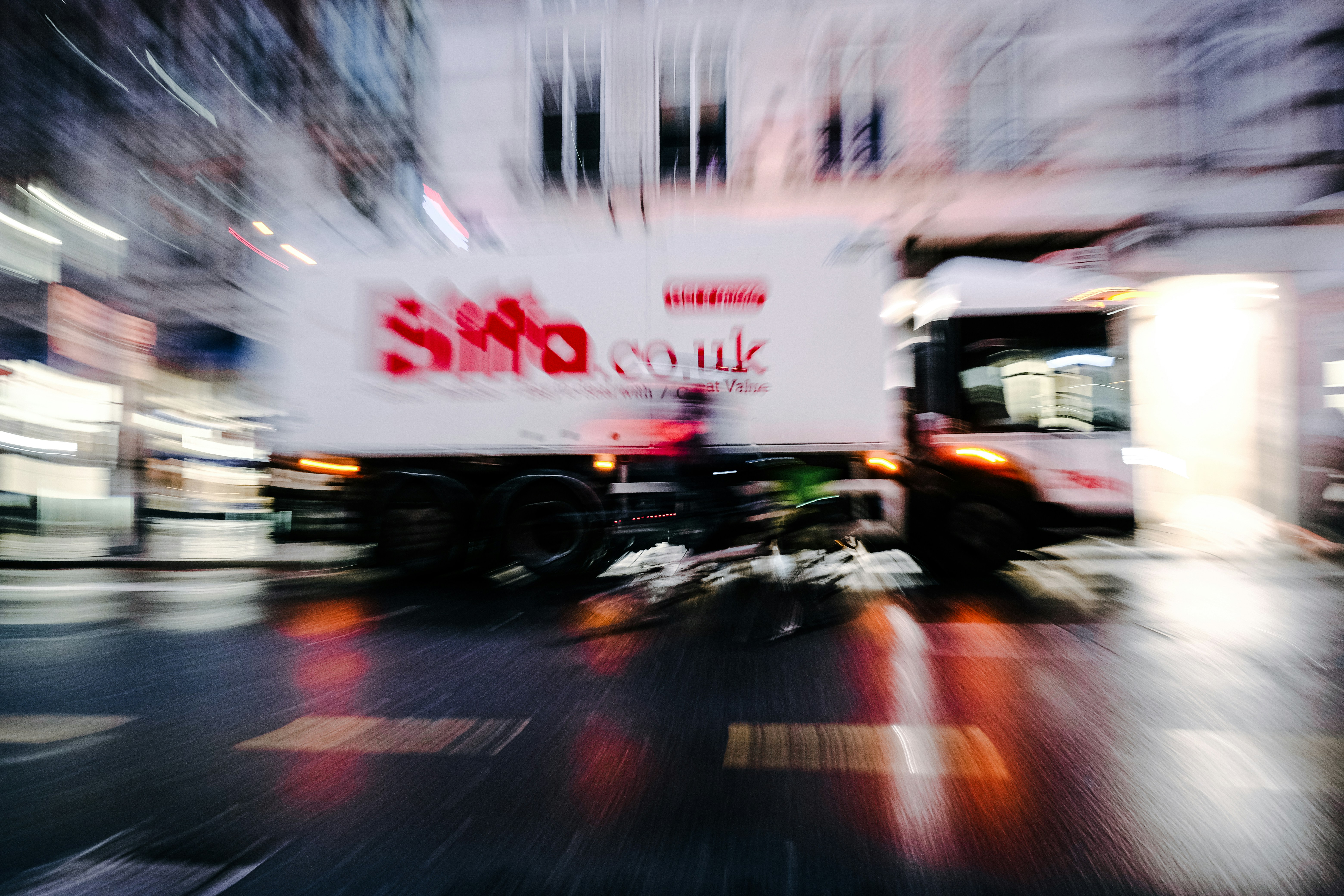 Truck driving on wet street at night
