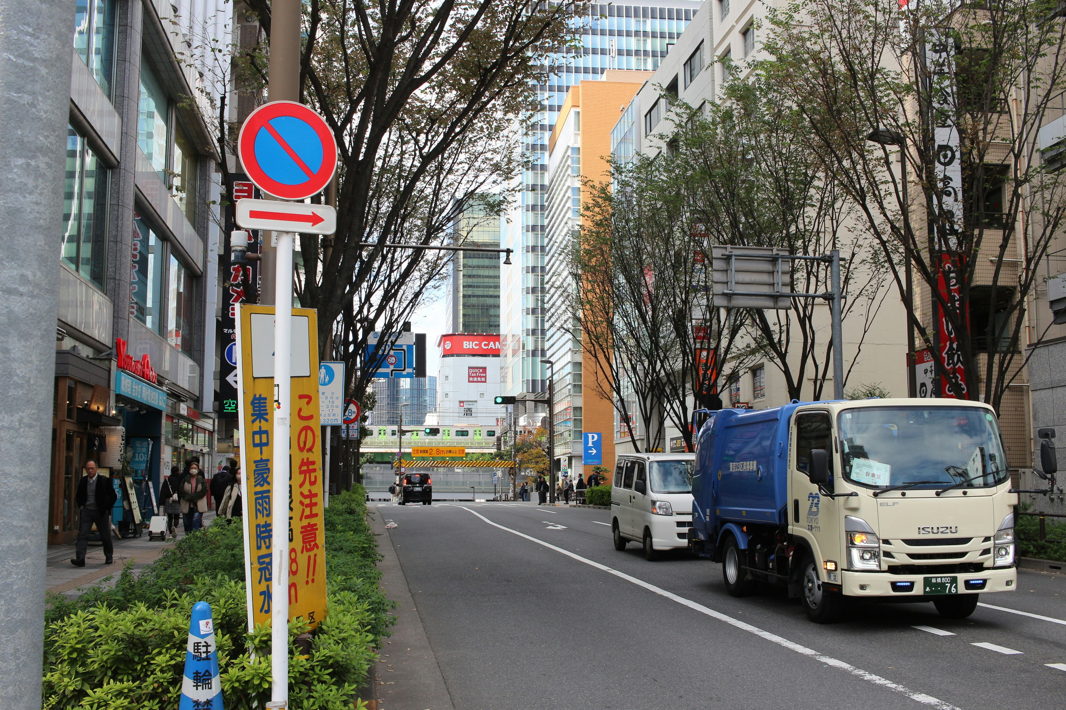 Street scene with buildings, cars, and trees.