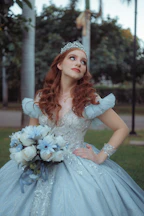 Young woman in a blue ballgown with tiara and bouquet.