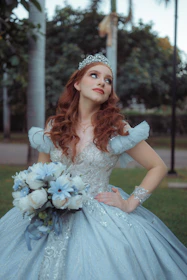 Young woman in a blue ballgown with tiara and bouquet.
