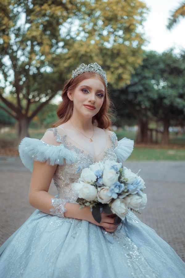 Regina Sofía en un retrato de día en el parque, sosteniendo su ramo de rosas blancas y azules