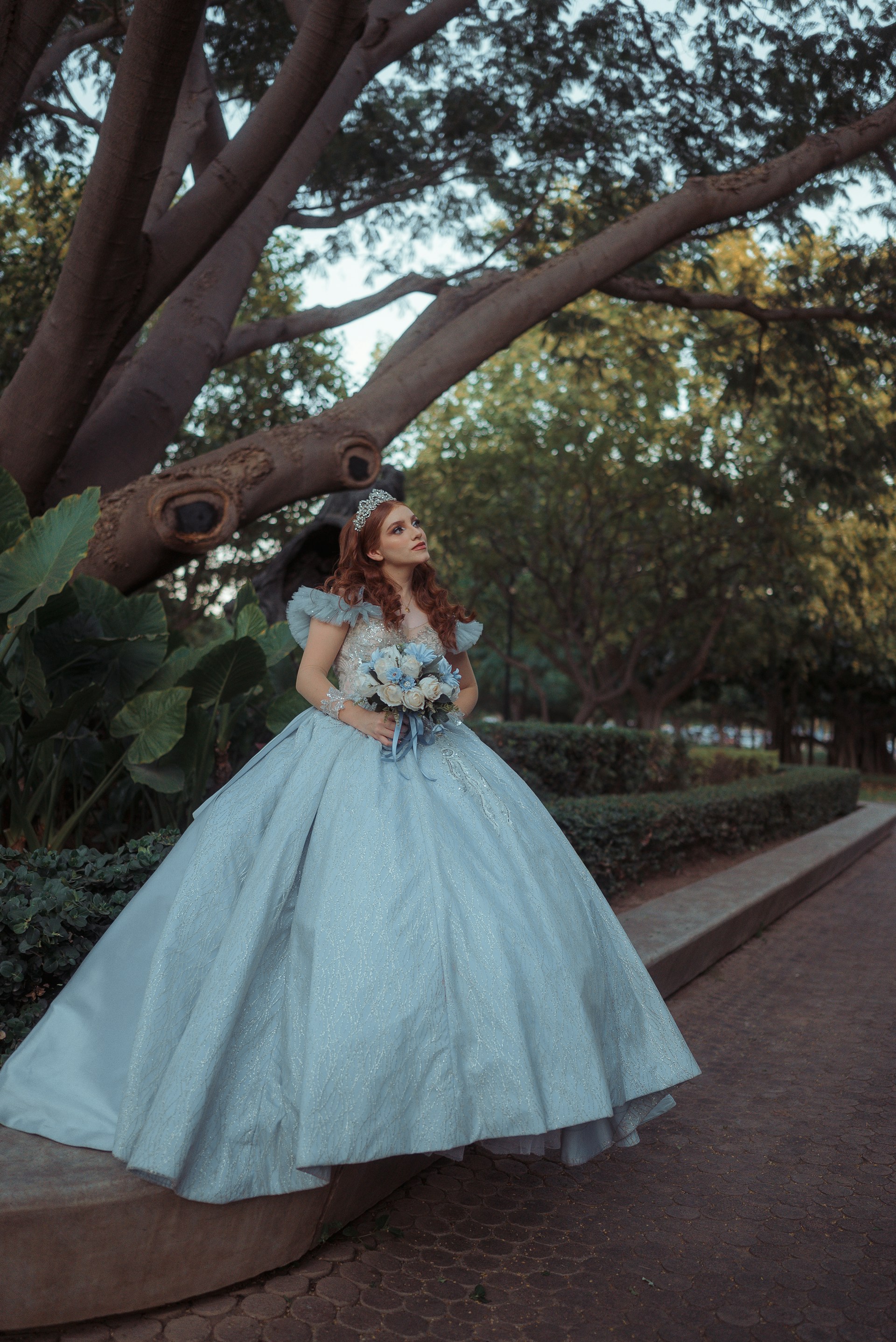 Woman in a light blue ballgown holding a bouquet