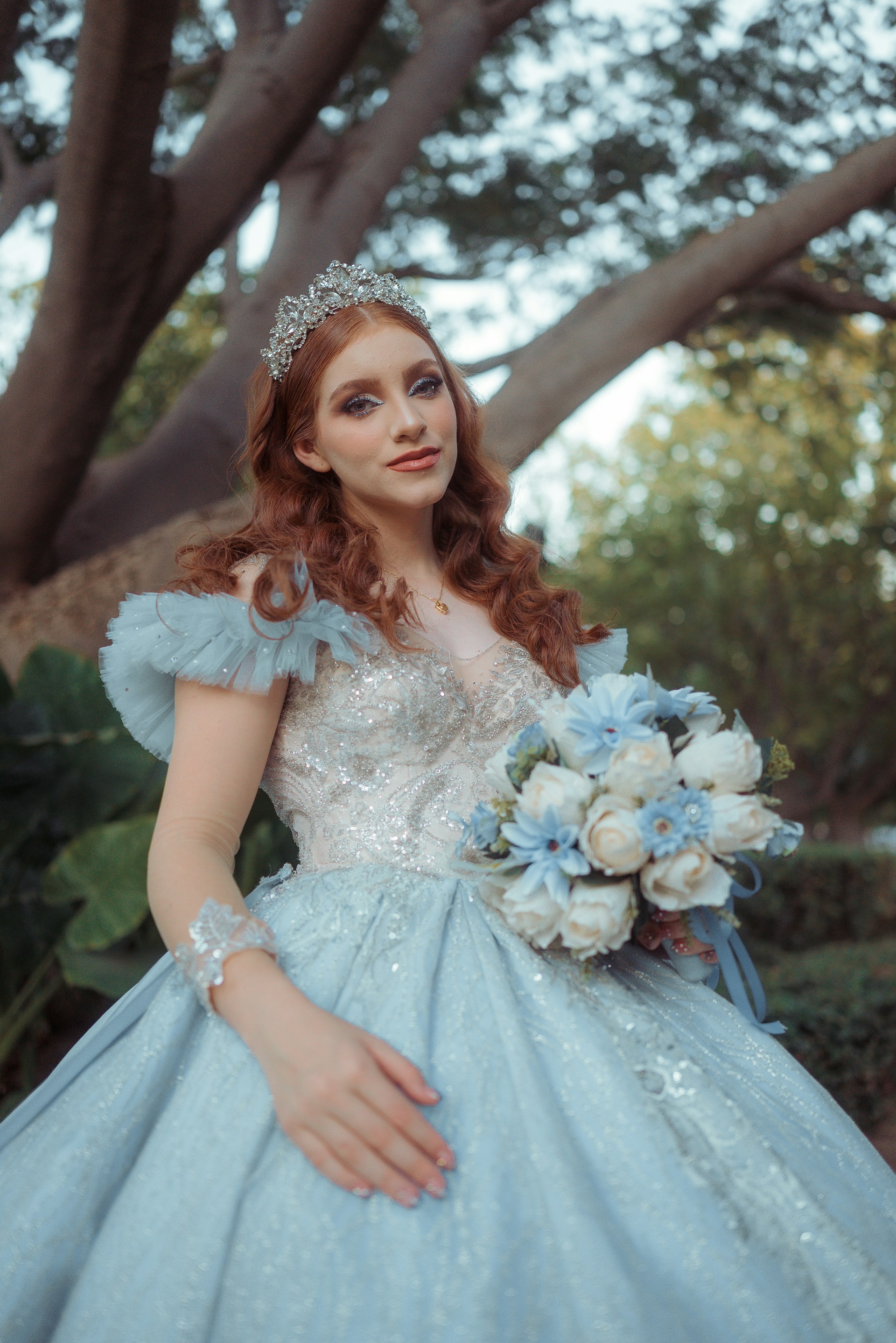 Young woman in a light blue gown holding a bouquet