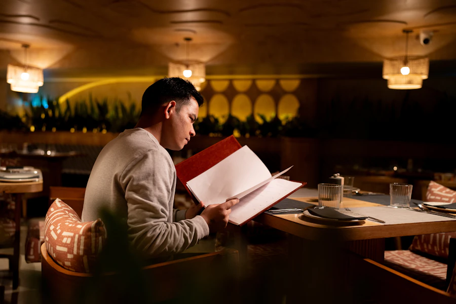 A man reading a menu at a restaurant table