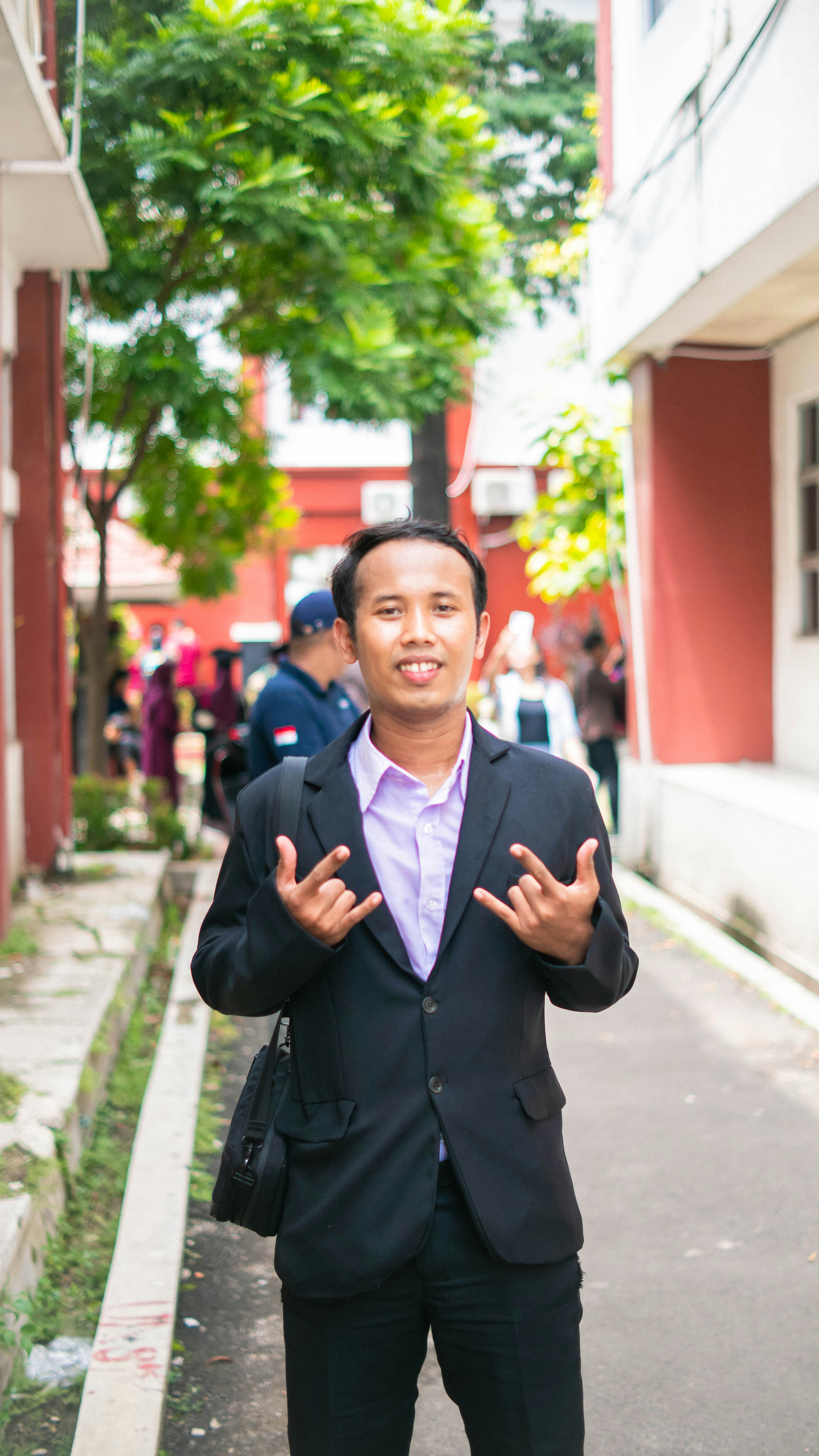 Man in suit making rock on hand gesture