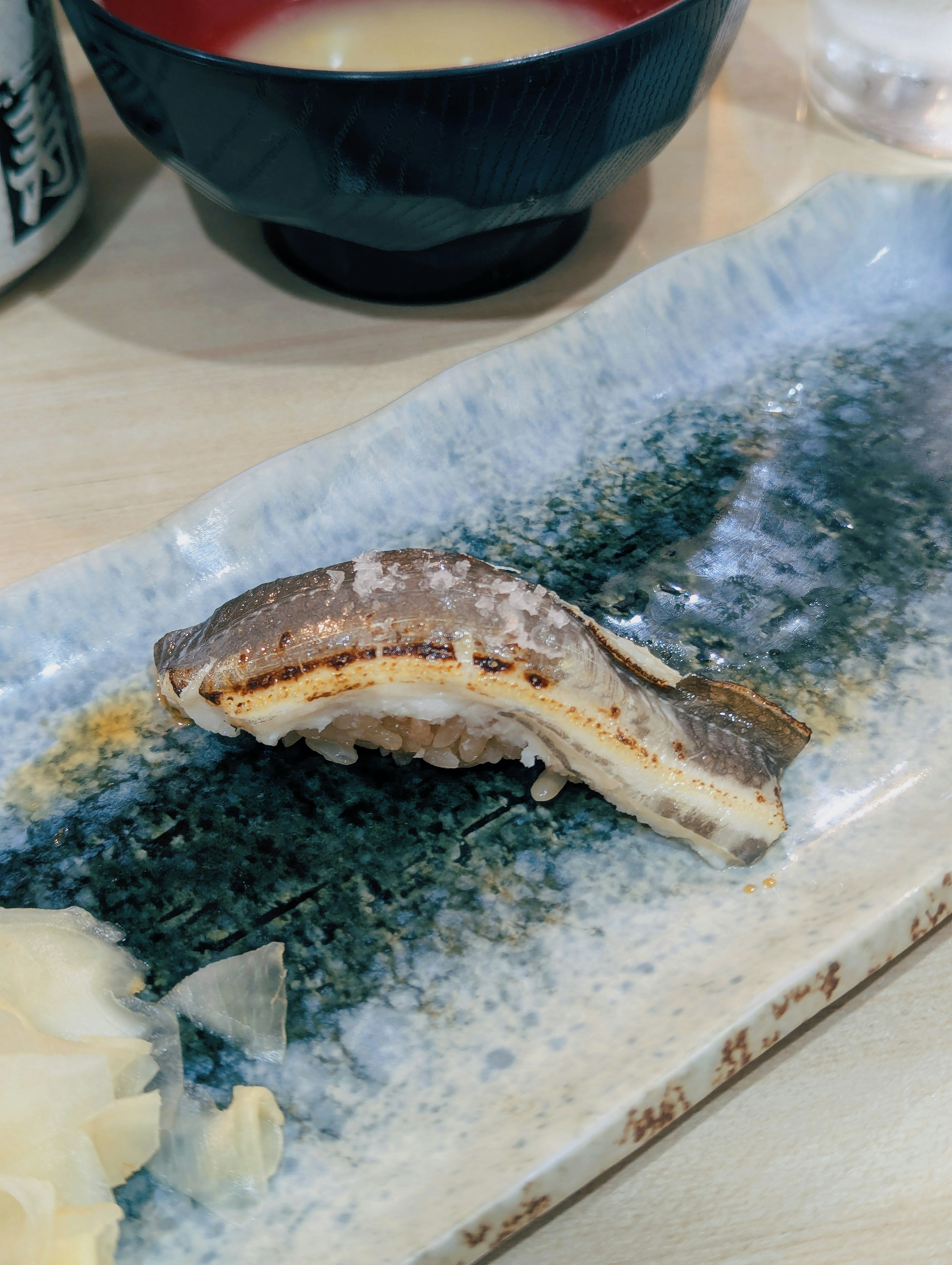 Grilled eel sushi on a decorative plate with ginger