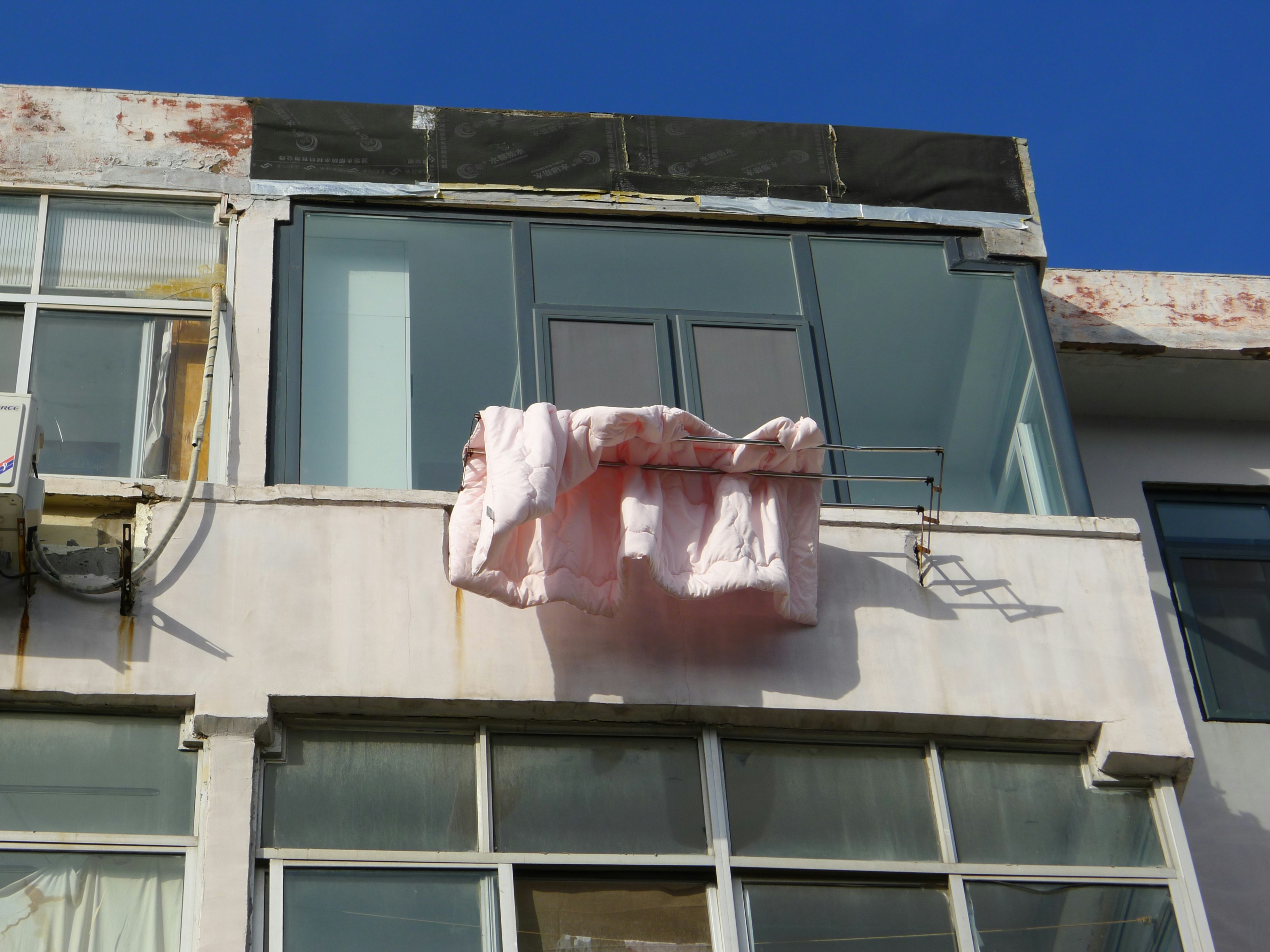 Licensed plumber fitting a new hot water unit on a Dee Why balcony