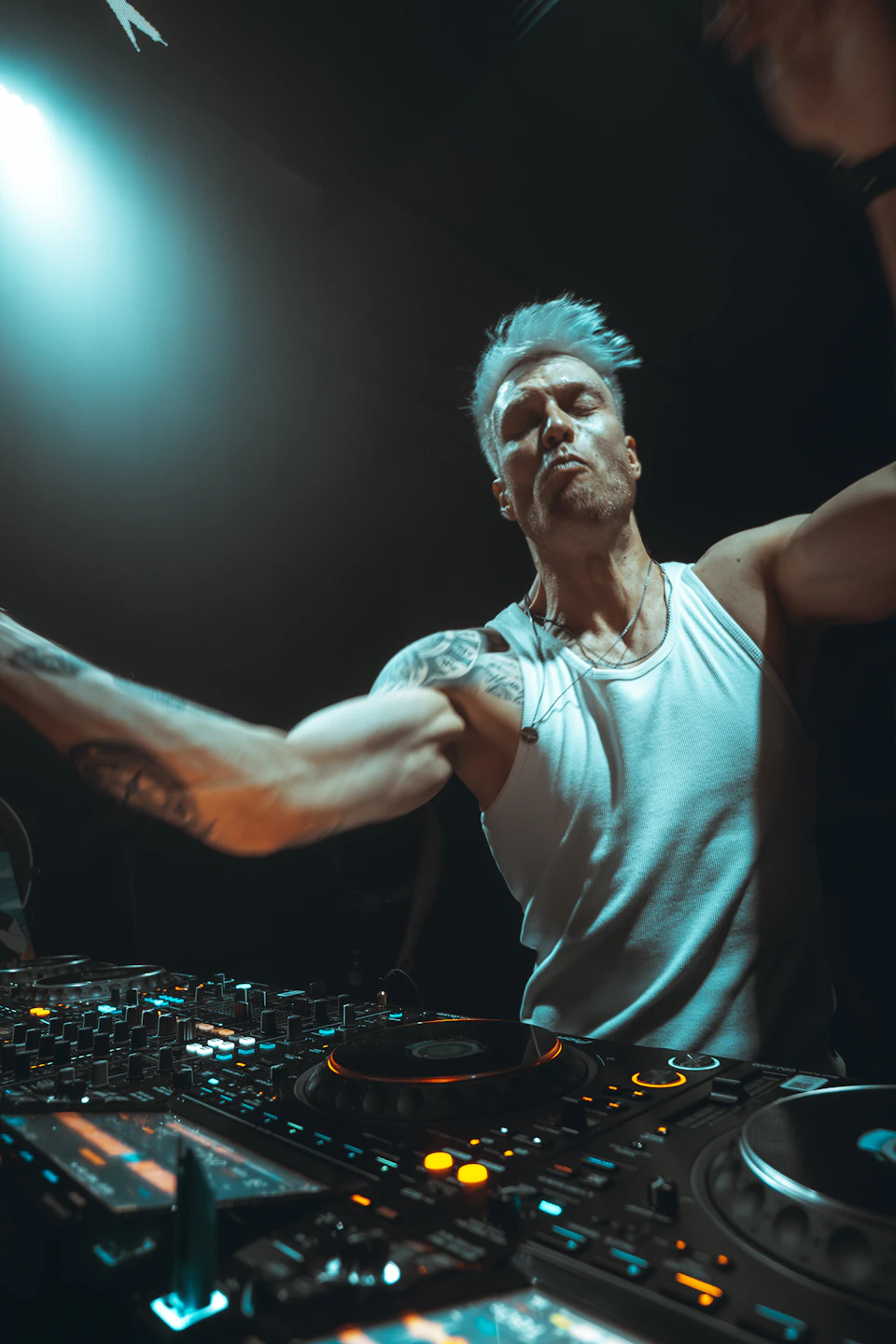DJ tampil merentangkan tangan di atas peralatan