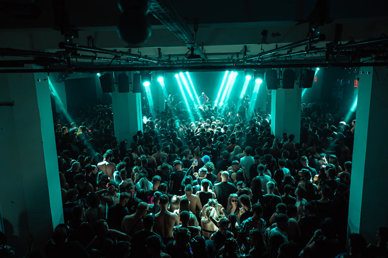 crowd dancing under teal concert lights