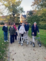 A family walks together on a park path.